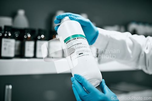 Image of Science, pharmaceutical chemical and bottle hands from shelf in laboratory for medical research. Healthcare, medicine and innovation in manufacturing of vaccine or prescription drugs with scientist.