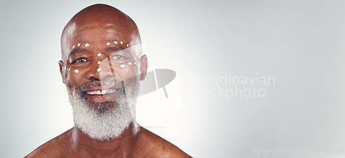 Image of Skincare, portrait and senior man relax in studio with face cream, sunscreen and product on grey background. Facial, wrinkles and elderly model happy with skin, treatment and luxury cosmetics