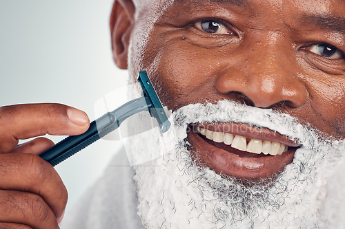 Image of Black man, face zoom and shaving cream with razor, portrait for beauty and grooming isolated on studio background. Facial hair removal, happy elderly person and hygiene with skincare and wellness