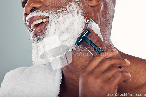 Image of Black man shaving, face and cream with razor, healthy skin with beauty and grooming isolated on studio background. Facial hair removal, happy elderly person and hygiene with skincare and wellness