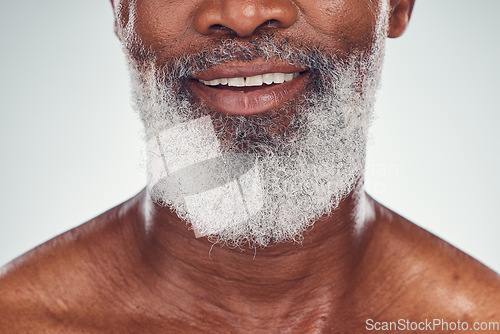 Image of Smile, beard and face with a senior black man grooming in studio on a gray background for beauty or skincare. Skin, hygiene and cosmetics with a mature male indoor to promote facial hair maintenance