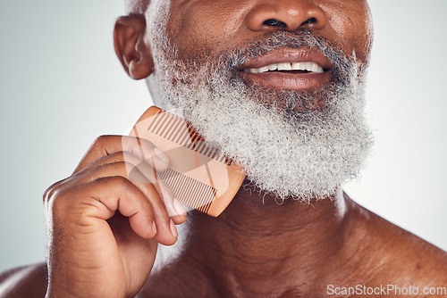 Image of Grooming, comb and barber with beard of black man for beauty, hygiene and skincare. Self care, facial hair and maintenance with senior model for health, wellness and cleaning in studio background