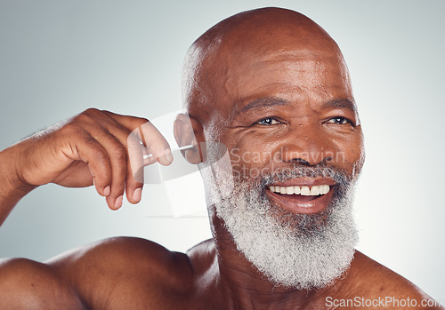 Image of Cleaning, ear and black man with earbuds, smile on face and body care grooming isolated on grey background. Morning routine, health and happy senior male in mockup, clean ears and wellness in studio.