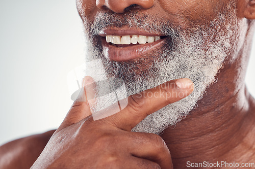 Image of Hand, beard and smile with a senior black man grooming in studio on a gray background for beauty or skincare. Skin, hygiene and cosmetics with a mature male indoor to promote facial hair maintenance