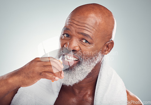 Image of Black man brushing teeth, portrait and toothbrush, mouth care and fresh breath, hygiene isolated on studio background. Health, wellness and cleaning with dental, senior person and retirement