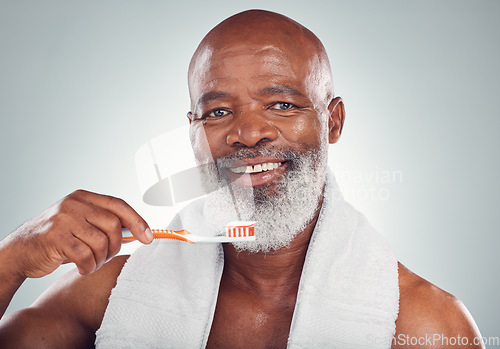 Image of Black man brushing teeth, smile and toothbrush, mouth care and fresh breath, hygiene isolated on studio background. Health, wellness and cleaning with dental portrait, senior person and retirement