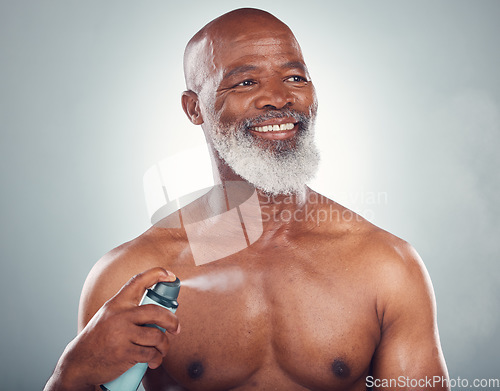 Image of Old man, spray body with skin and smile for beauty, grooming and hygiene isolated on studio background. Happiness, wellness and skincare, cosmetic product and topless with perfume and fragrance