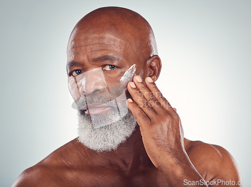 Image of Face cream, skincare and senior man in studio for wellness, beauty and grooming against grey background. Facial, skin and elderly model relax with luxury, cosmetics and wrinkle product while isolated