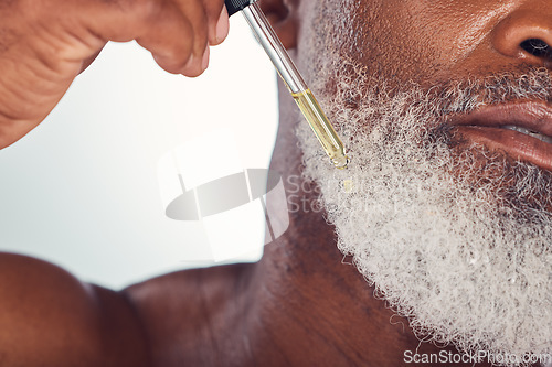 Image of Closeup, black man and serum for beard, cosmetics and hygiene for wellness, natural beauty and grey studio background. Senior male, mature guy and oil for hair care, grooming routine and treatment