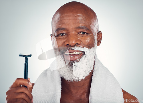 Image of Black man, face and shaving cream with razor, portrait for beauty and grooming isolated on studio background. Facial hair removal, happy elderly person and hygiene with skincare and wellness