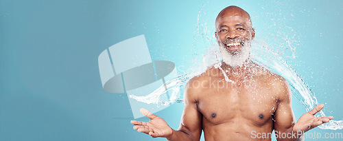 Image of Portrait, old man and water splash in studio for beauty, grooming and skincare on blue background. Elderly, model and guy relax while cleaning, hygiene and skin wellness, hydration and isolated