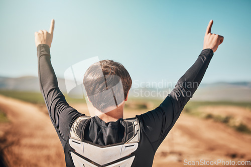 Image of Winner, hands and back of a sports man outdoor on a dirt track for racing, competition or adrenaline. Success, celebration and winning with a male athlete or biker standing hands raised outside