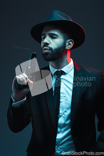 Image of Man, suit or blowing gun barrel on dark studio background in secret spy, isolated mafia leadership or crime lord safety. Model, gangster or hitman pistol in style, formal or fashion clothes aesthetic
