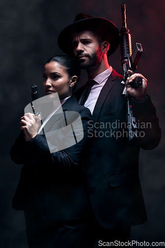 Image of Gangster couple, fashion or gun on studio background in secret spy, isolated mafia safety or crime lord security. Man, love or model woman with pistol in stylish, trendy or fashion clothes aesthetic