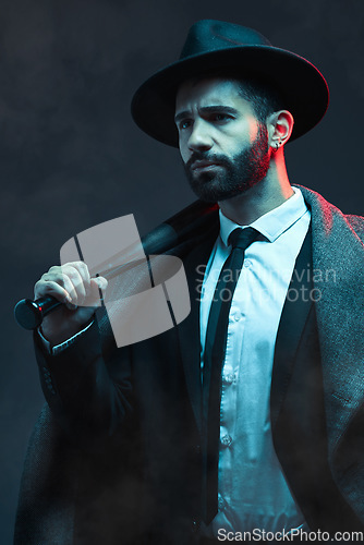 Image of Fashion, criminal and man with bat for violence for vintage, retro and Victorian gangster on dark background. Crime aesthetic, thinking and male model with designer suit, weapon and threatening face