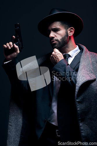 Image of Gangster, leadership or holding gun on studio background in dark secret spy, isolated mafia or crime lord security. Model, man and hitman suit with weapon in formal style or fashion clothes aesthetic