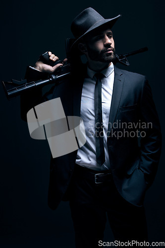 Image of Hitman, suit or holding gun on studio background in dark secret spy, isolated mafia leadership or crime lord security. Model, man or gangster weapon in formal, fashion clothes or bodyguard aesthetic