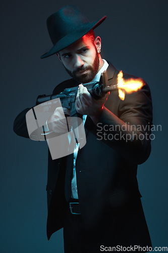 Image of Man, suit or shooting gun on dark studio background in secret spy, isolated mafia leadership or crime lord security. Model, gangster or hitman firing gun in style, formal or fashion clothes aesthetic