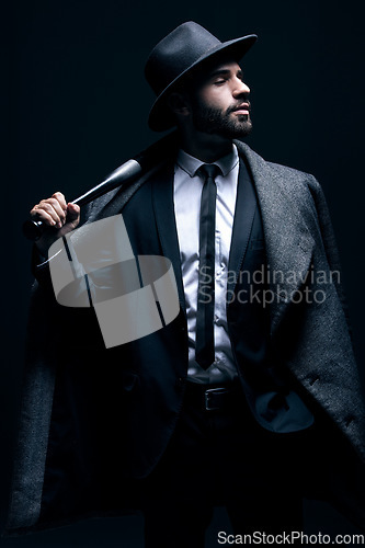 Image of Criminal, fashion and man with bat for vintage, retro and Victorian gangster on dark background. Crime aesthetic, violence and male model with baseball weapon, threatening attitude and confidence