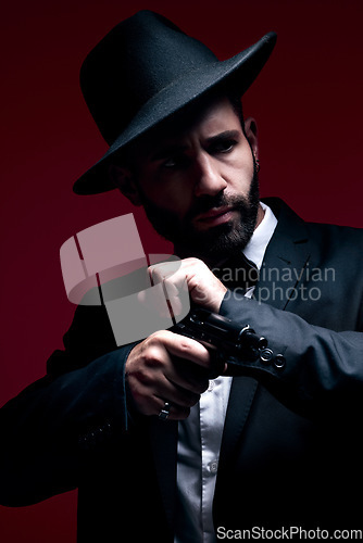 Image of Gangster, suit or cocking gun on studio background in dark secret spy, isolated mafia leadership or crime safety. Model, assassin or hitman weapon in ready, formal style or fashion clothes aesthetic