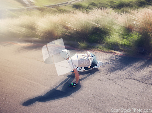 Image of Skate, blurred motion and fast with a sports man skating on an asphalt road outdoor from the back. Skateboard, soft focus and speed with a male athlete or skater training outside on the street