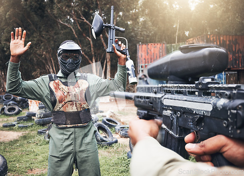 Image of Paintball, gun and soldier target of military, war and army game training in a forest for exercise. Man surrender, sports and battlefield shooting outdoor in a field for fitness and sport training