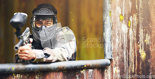 Image of Paintball, gun and war with a sports man playing a military game for fun or training outdoor. Camouflage, soldier and target with a male athlete shooting a weapon outside during an army exercise