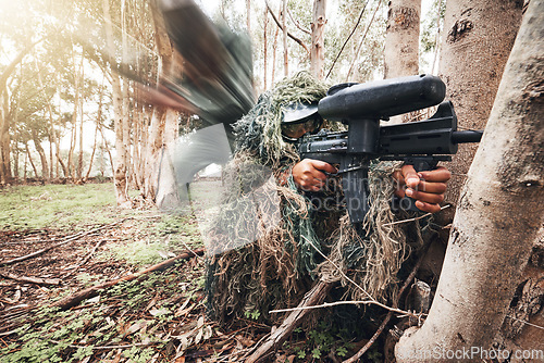 Image of Paintball gun, forrest men and aim by trees for outdoor war game, strategy or teamwork in natural camouflage. Shooter, sniper and helmet for safety with eyes on target, shooting or military exercise