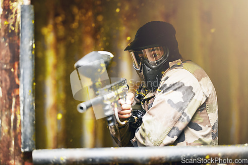 Image of Paintball, war and camouflage with a sports man playing a military game for fun or training outdoor. Gun, soldier and target with a male athlete shooting a weapon outside during an army exercise