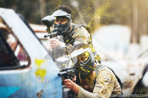 Image of Paintball, shooting and people in action competition, game or match as a competitive team on a battleground. Aim, gun and player or teamwork of group in extreme sports with camouflage and safety mask