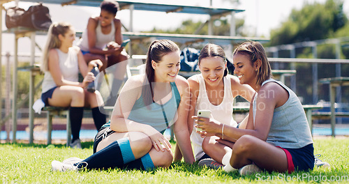 Image of Sports, women and group outdoor, smartphone and connection with girls on field, chatting and relax. Fitness, female athletes smile and young ladies with cellphone, summer and on break after training