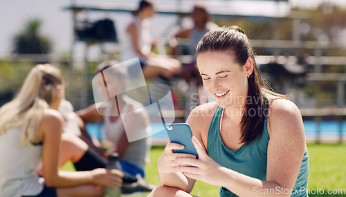 Image of Woman, sports field and texting with phone, social media and communication for online dating, happy or smile. Gen z girl, cellphone and outdoor happiness for chat app, web or laugh at meme on website