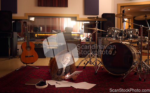 Image of Music studio, tablet and black woman on floor with paper online for notes, lyrics and inspiration on internet. Musical instruments, creative industry and girl musician with digital tech for research