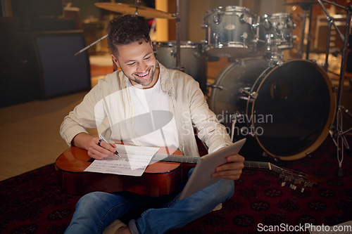 Image of Happy, tablet and musician writing a song for a performance on a video call in the studio. Creative, planning and artist with a guitar for music production with technology for a sound website