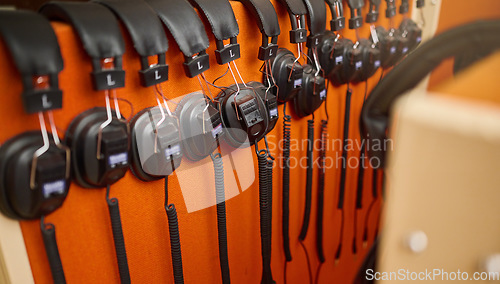 Image of Radio, music and headphones hanging on a wall for a dj, podcast or audio production in the studio. Sound, electronics and equipment for streaming songs, listening to a track or musical accessory