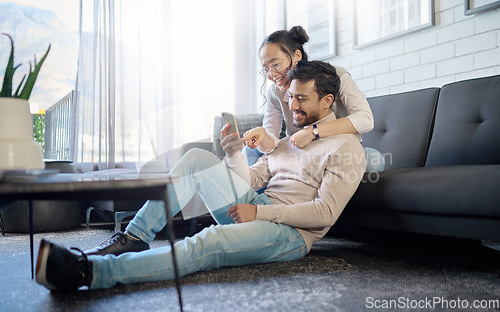 Image of Interracial, couple and people with phone on social media laughing at meme or funny internet content. Man, woman and lovers relax in home, house or apartment browsing the web, website or app