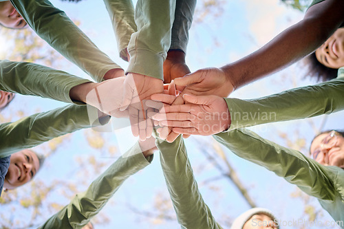 Image of Teamwork, collaboration and low angle of people with hands together for team building. Motivation, solidarity and group of men and women huddle for unity, union or community, support or cooperation.