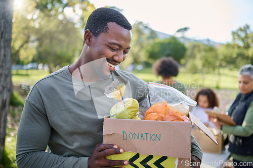 Image of Food, donation and man in park with smile and grocery box, happy, healthy diet at refugee feeding project. Fresh fruit, charity donations and help to feed people, support from farm volunteer at ngo.