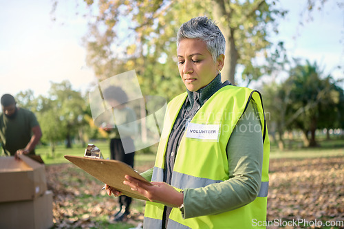 Image of Volunteer, clipboard and senior woman with checklist in park for charity, planning and organized donation. Community, service and elderly lady checking list in forest for environment, help or project