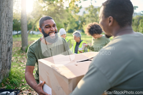 Image of Community service, black man and giving box in park of donation, volunteering or social responsibility. Happy guy, NGO workers and helping with package outdoor of charity, support or society outreach