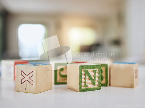 Image of Wood blocks, table and letters for learning, education or childhood development at home. Colorful wooden cube toys to learn numbers or alphabet for back to school, spelling or mathematics to read