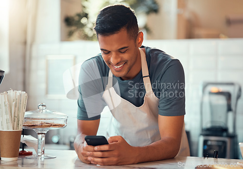 Image of Phone, small business and barista man in cafe shop for networking, online sales management and ecommerce. Happy waiter, cashier or worker person on smartphone, technology application in restaurant