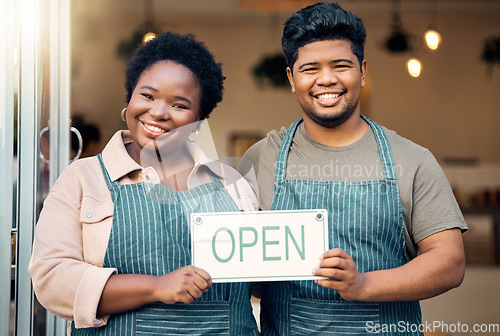 Image of Portrait, couple and open sign by small business owners happy at coffee shop, cafe and support together. Team, restaurant and black people smiling due to startup growth and proud of success or vision