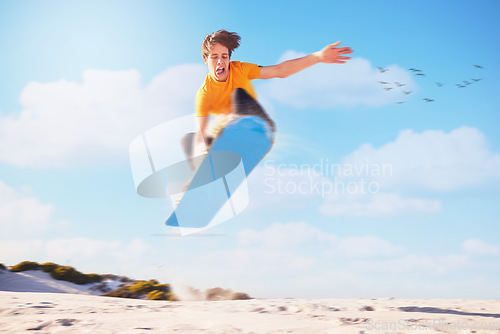 Image of Sport, sandboard man jumping man in a desert for extreme sports, fitness and training against blue sky background. Sandboarding, jump and guy in dunes with energy, freedom and adrenaline in Dubai