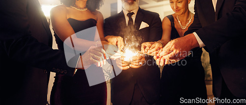 Image of Fire, sparklers and people at a luxury party, event or celebration for new year with formal outfit. Celebrate, matches and group of friends in classy clothes at a black tie gala, banquet or dinner.