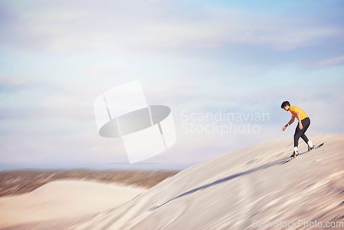 Image of Sandboard, desert and mockup with a sports man outdoor on the sand dunes for recreation, fun or adventure. Sky, nature and mock up with a male athlete or sandboarding moving downhill at speed