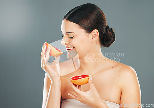 Image of Grapefruit, skincare woman or spa wellness for healthy diet, happy results or vitamin C on grey background. Beauty, smile or girl model face, facial makeup or aesthetic cosmetics for health in studio