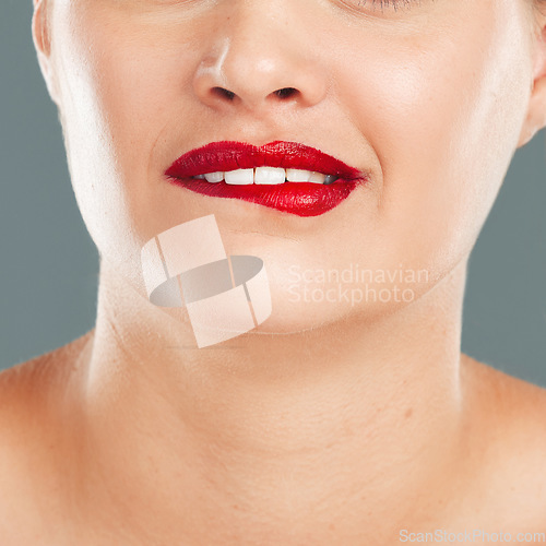 Image of Woman bite lips with lipstick, face zoom and makeup, flirt with red cosmetics isolated on studio background. Sexy mouth, beauty and skincare with cosmetic wellness and glow, facial and healthy skin