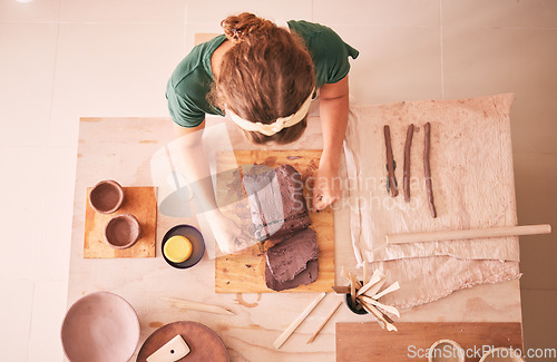 Image of Pottery, creative and startup with a woman designer working in her studio for art from above. Manufacturing, small business and scupture with a female entrepreneur, employee or artist in a workshop