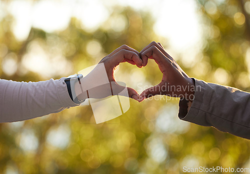 Image of Hands, heart and love with a couple outdoor on a date, bonding during summer for romance. Nature, emoji or hand sign with a man and woman outside in a park or natural environment on a sunny day